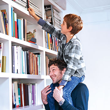 IDEAL ZukunftsRente: Vater mit Kind auf den Schultern vor einem Bücherregal
